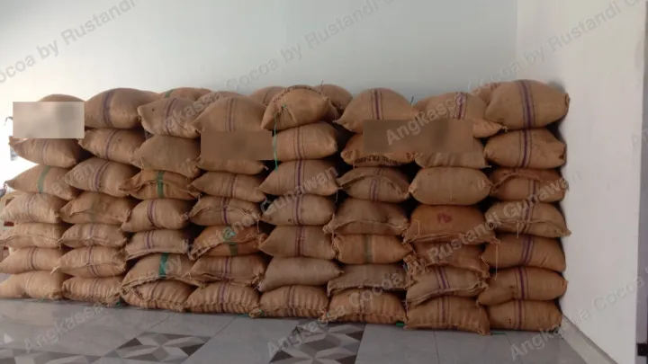 Puluhan karung goni tersusun rapi menempel dinding.