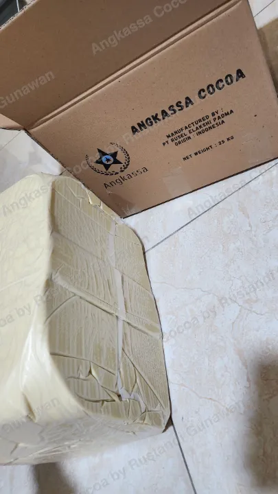 Balok cocoa butter di samping kardus bertulisan Angkassa Cocoa.