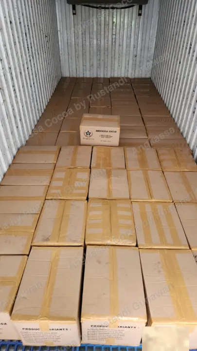 Lantai kontainer penuh kardus, satu kardus Angkassa Cocoa di atasnya.